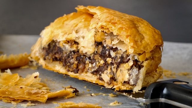 Close up inside a rich puff pastry wellington stuffed with porcini mushrooms and lentils