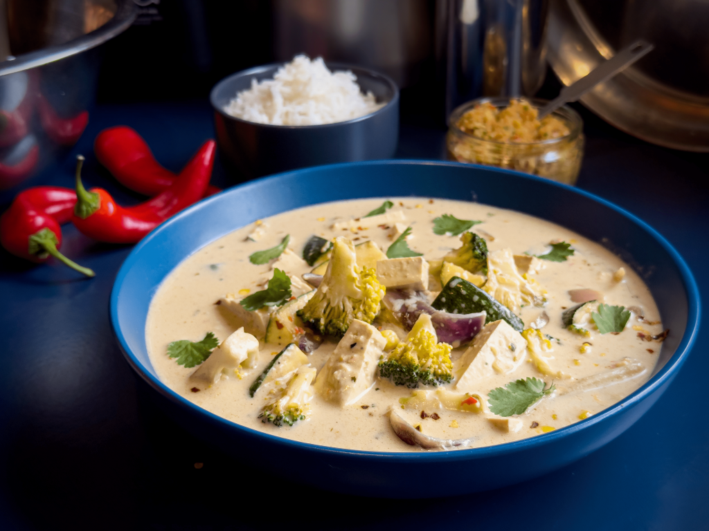 A bowl of sumptuous thai red curry with tofu and vegetables.