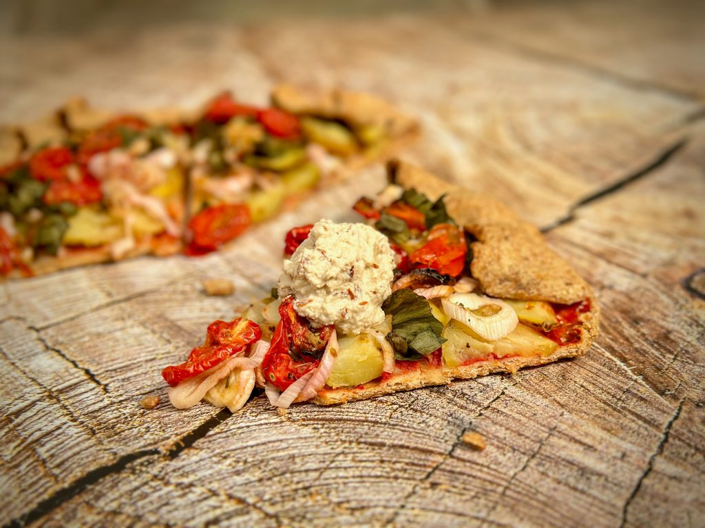 Dollop of almond and cashew ricotta on top of tomato and new potato crostata