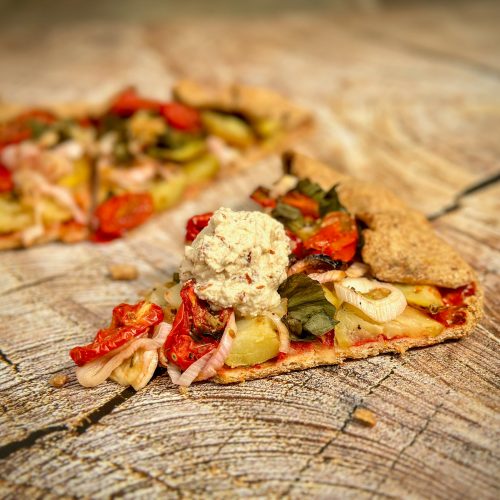 Dollop of almond and cashew ricotta on top of tomato and new potato crostata