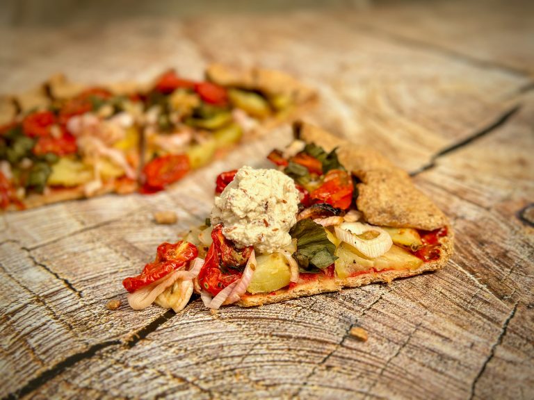 Dollop of almond and cashew ricotta on top of tomato and new potato crostata