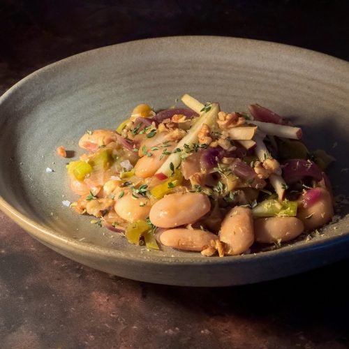 a cosy grey bowl of cider-braised butterbeans dressed with shards of red apple and pear, with lots of fresh thyme.