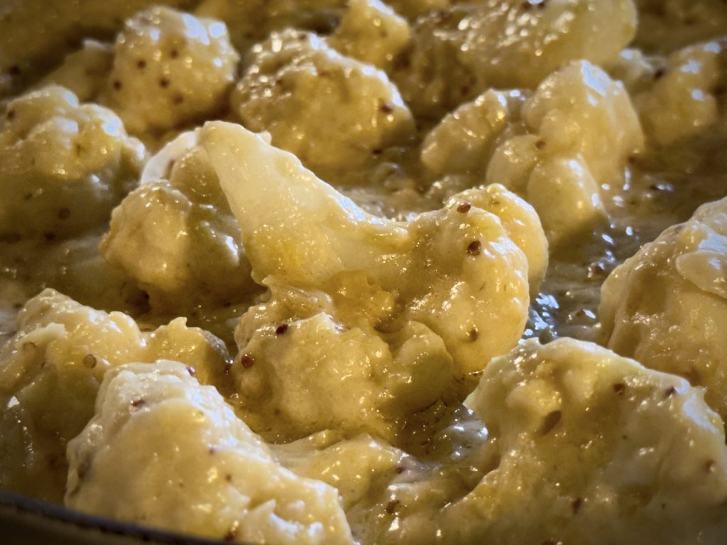Close up of creamy cheesy cauliflower cheese, luscious and rich