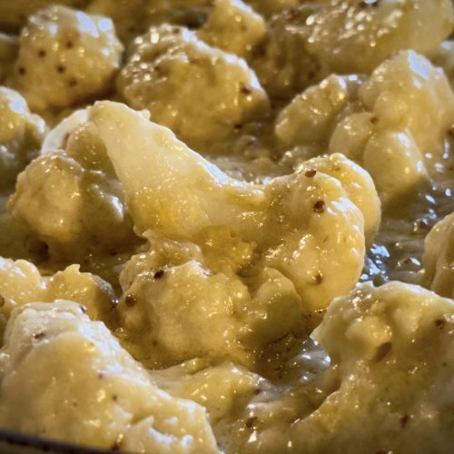 Close up of creamy cheesy cauliflower cheese, luscious and rich